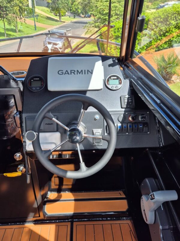 Interior helm view of 6.25m Pro Fisher boat showing Garmin steering wheel and console