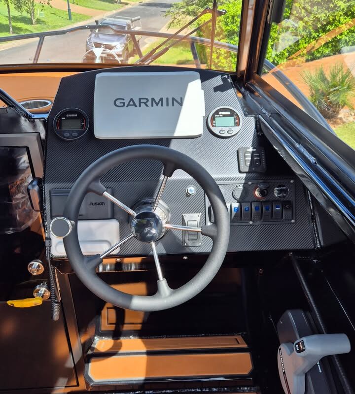 Interior helm view of 6.25m Pro Fisher boat showing Garmin steering wheel and console