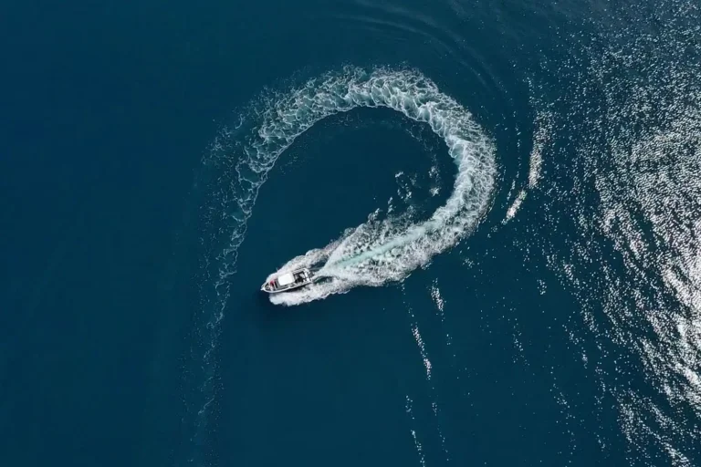 Aerial view of a plate aluminium boat carving a turn