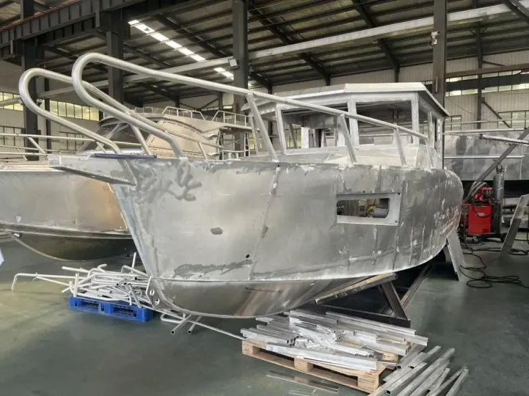 Bare aluminium hull with bow rails during build