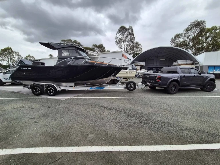 Black hardtop plate aluminium boat on a trailer at the yard