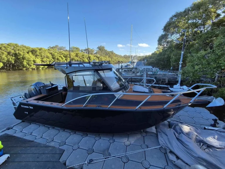 Black plate aluminium boat berthed at a river marina