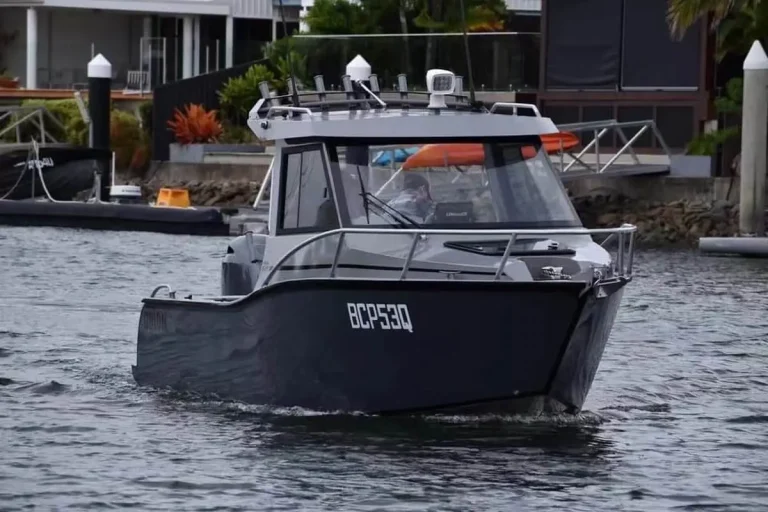 Black plate aluminium cabin boat moored at a jetty