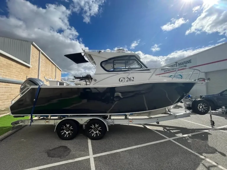 Black plate aluminium hardtop boat on a trailer at a dealership