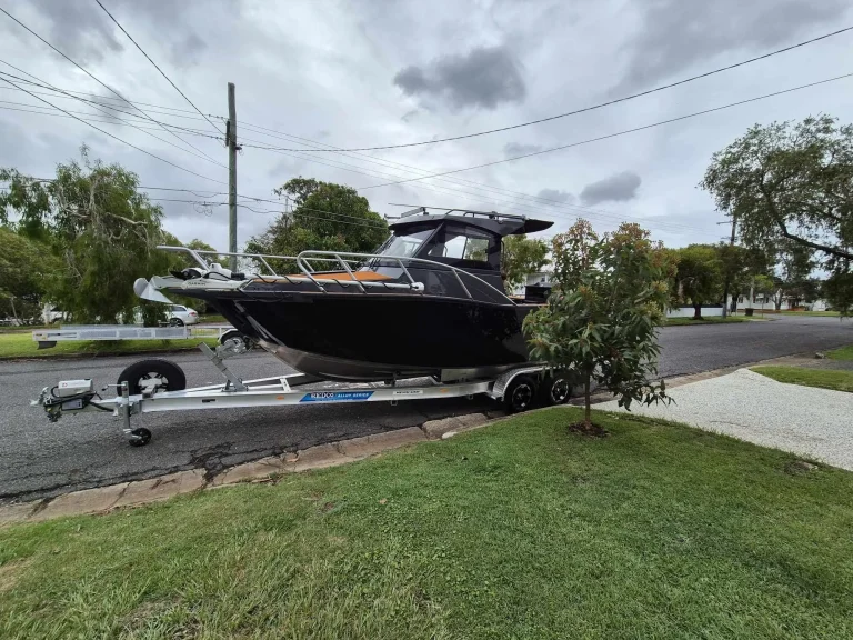 Black plate aluminium hardtop boat on a trailer on a lawn