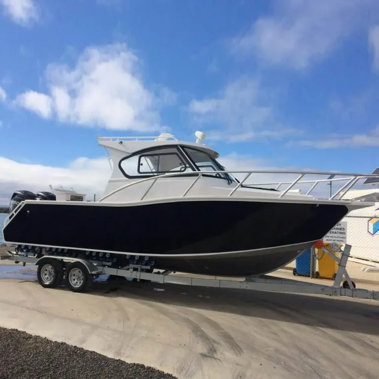 Black plate aluminium hardtop boat on a trailer outdoors