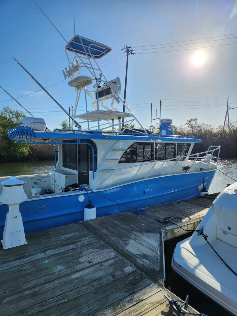 Blue and white plate aluminium charter boat at a jetty