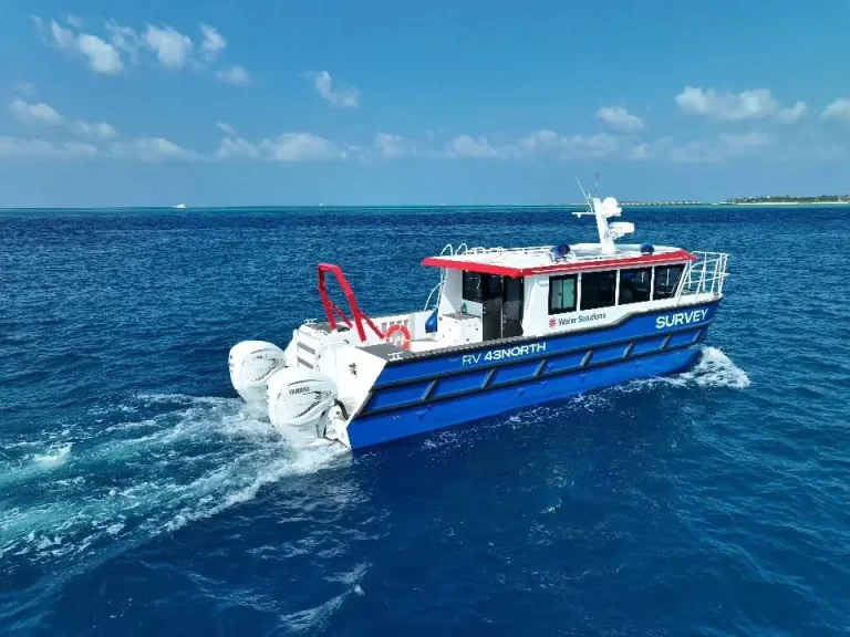 Blue and white plate aluminium work boat on tropical water