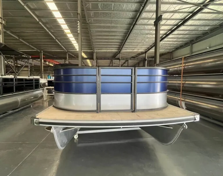 Blue and white pontoon boat with lounge seating in the factory