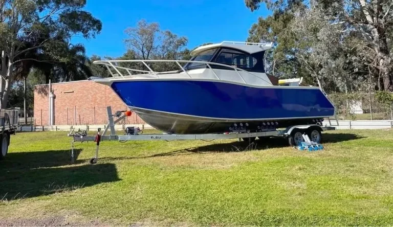 Blue hardtop plate aluminium boat parked on a lawn