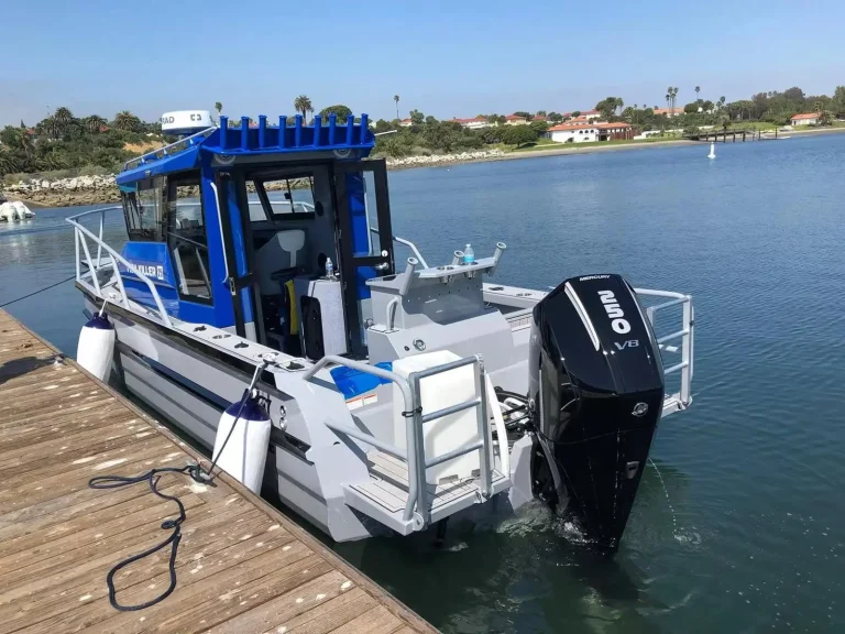 Blue plate aluminium boat with rocket launchers at a jetty