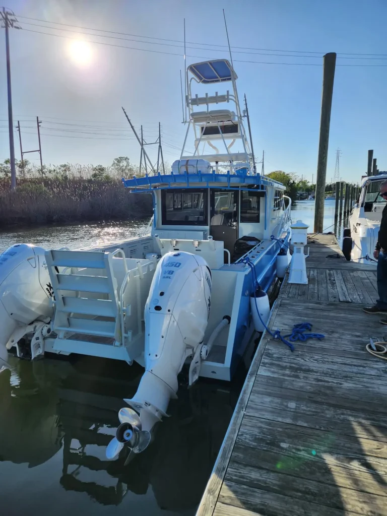 Blue plate aluminium charter boat with tower at a jetty