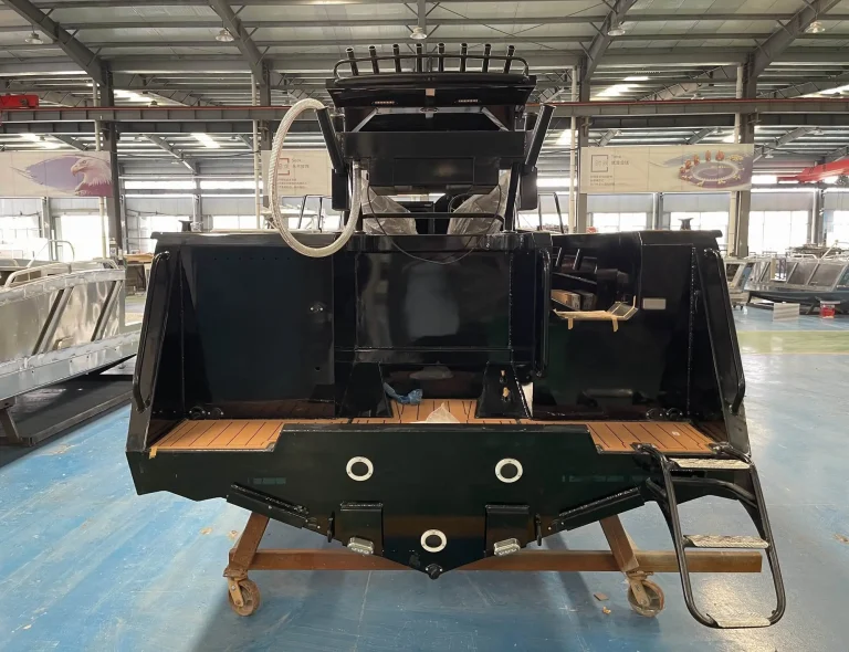 Bow of a black plate aluminium hull on the factory floor