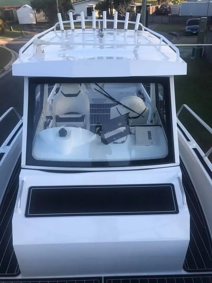 Bow on view of a white hardtop boat with rocket launchers