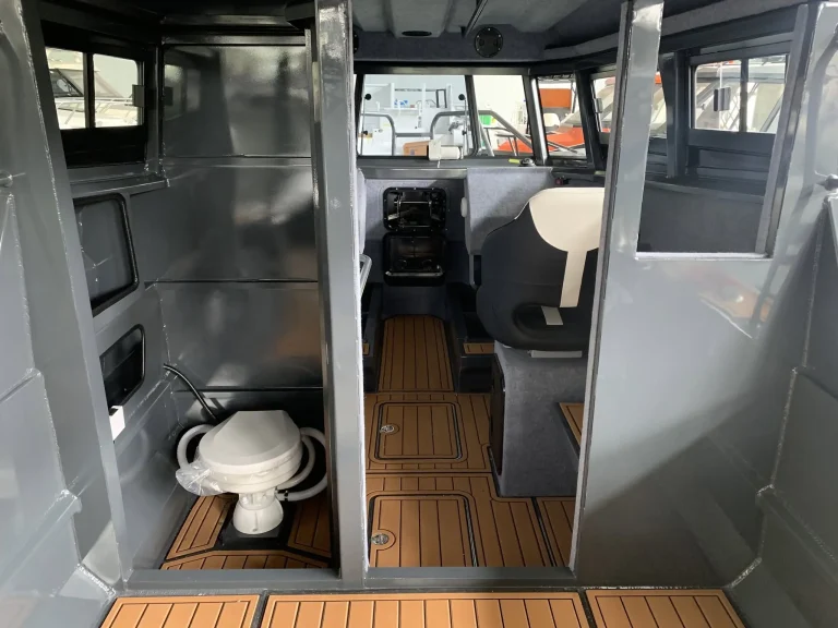 Cabin interior with toilet and teak look flooring