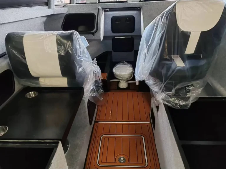 Cabin interior with wrapped seats and teak look flooring