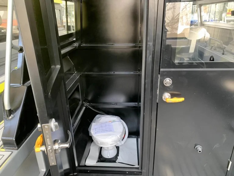 Compact toilet compartment beside the helm