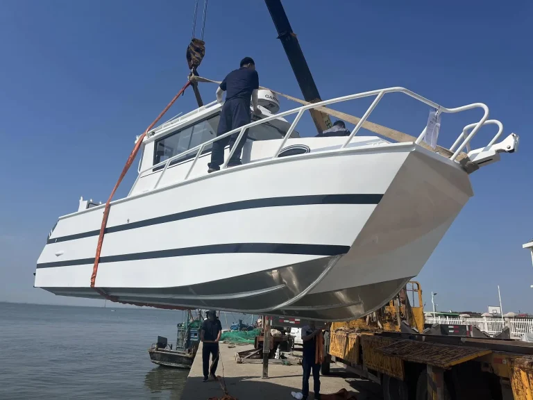 Crane lifting a plate aluminium hull at the slipway