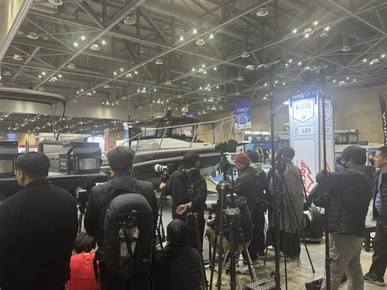 Crowd around a plate aluminium boat at a trade show