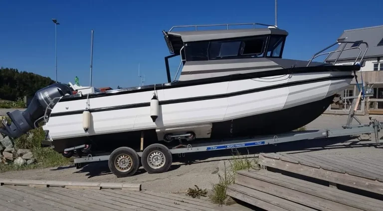Enclosed cabin plate aluminium boat with twin outboards on a trailer