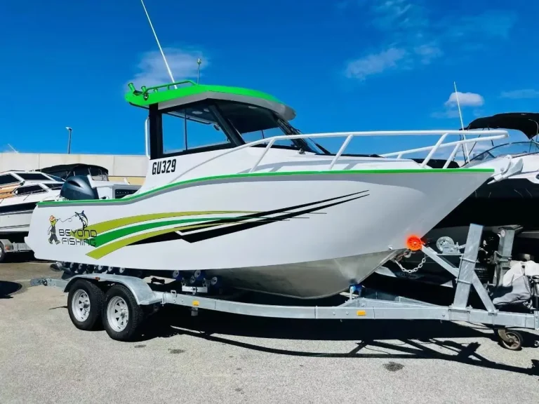 Green wrapped hardtop boat on a trailer at the ramp