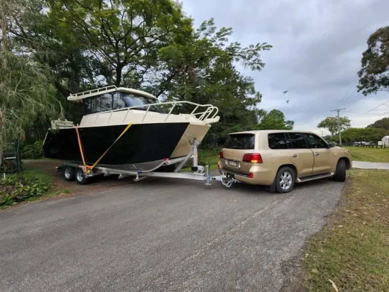 Hardtop cabin boat on a trailer behind a four wheel drive