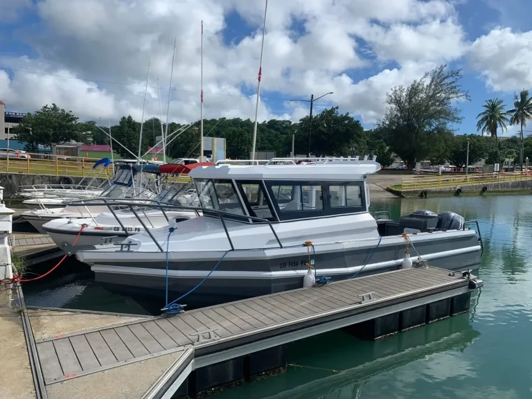 Hardtop plate aluminium fishing boat tied up at a tropical marina