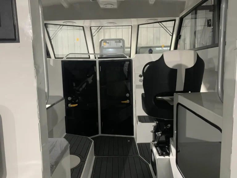 Helm seat and cabin door inside a plate aluminium boat