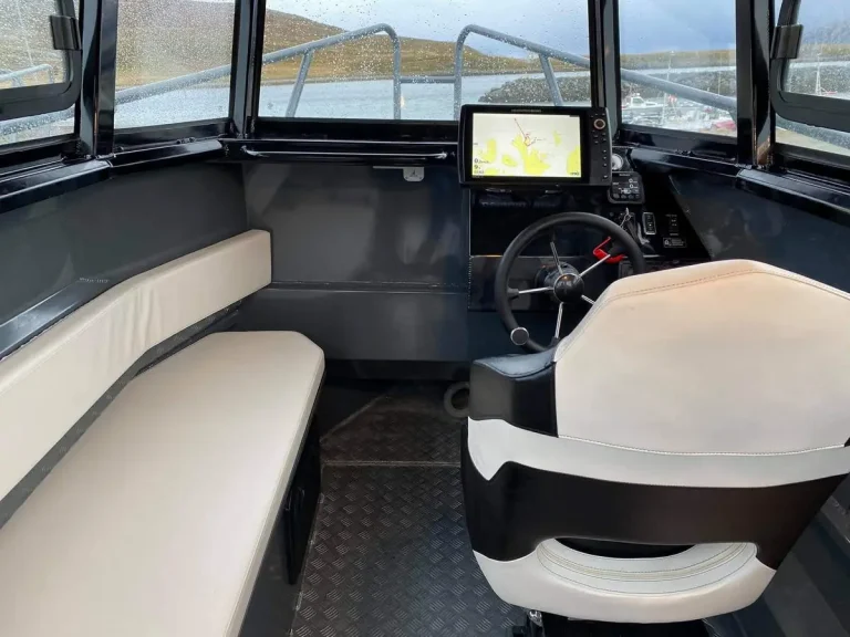 Helm seat, dash and chart plotter inside a cabin boat