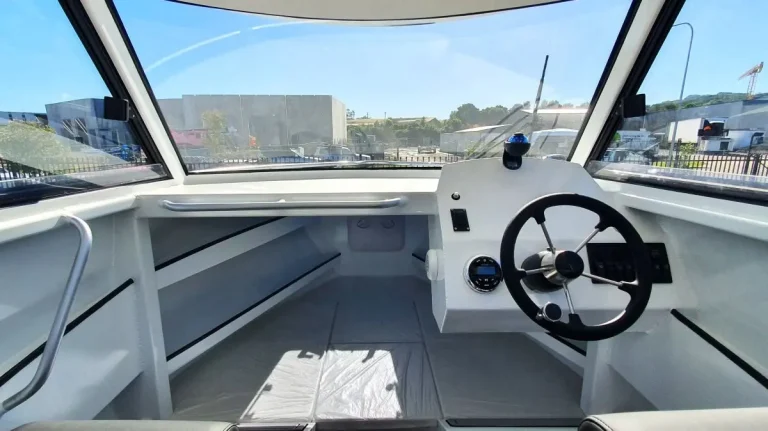 Helm wheel and windscreen looking out to the marina