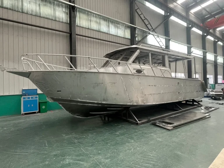 Long bare aluminium hull with cabin in the factory