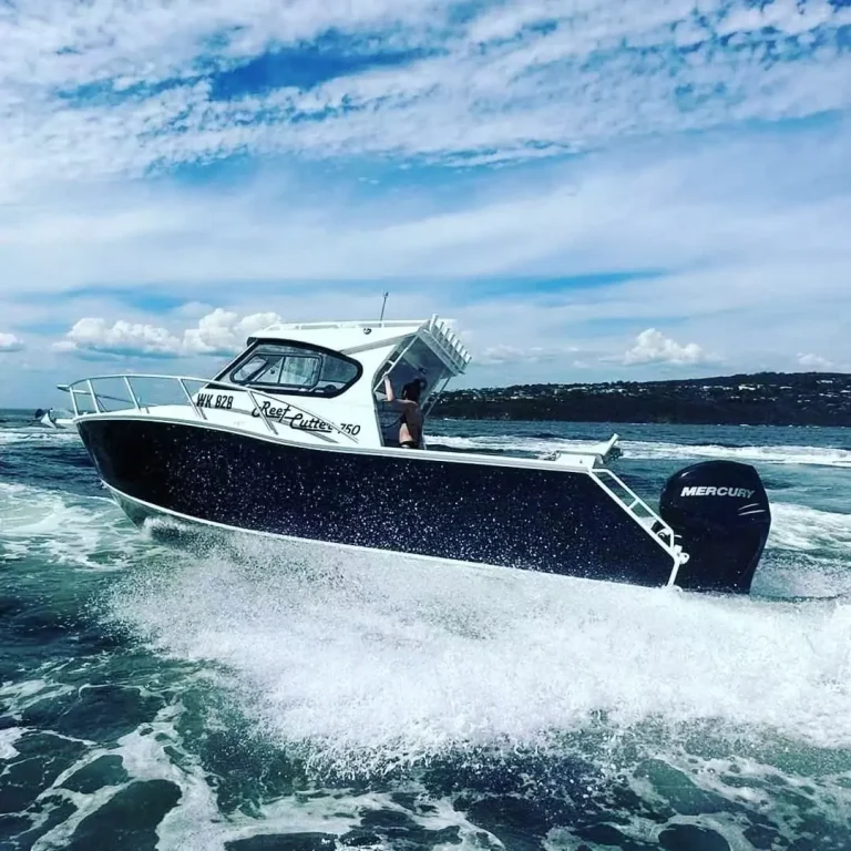 Navy plate aluminium boat powering through a swell