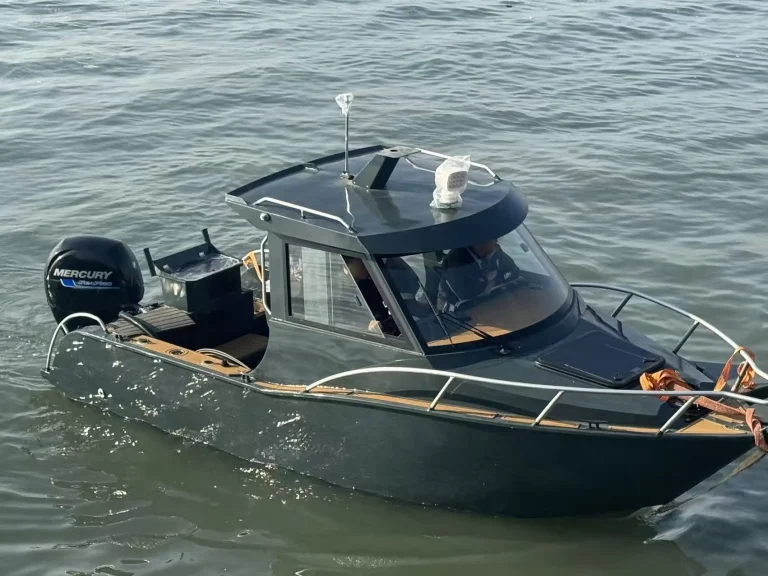 Navy plate aluminium cabin boat on calm water