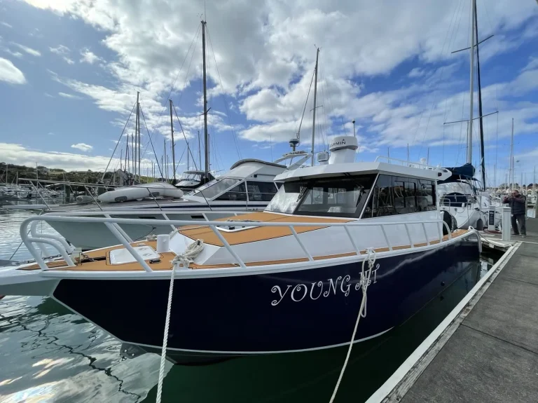 Navy plate aluminium cruiser moored among yachts