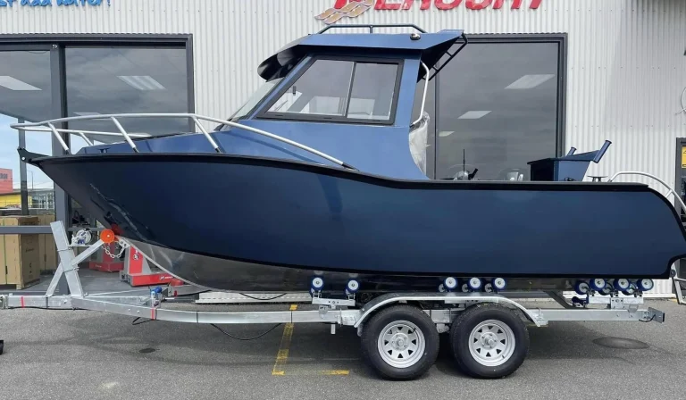 Navy plate aluminium hardtop boat on a tandem trailer