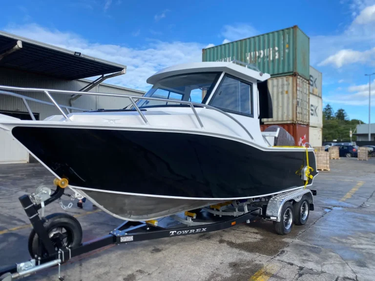 Navy plate aluminium hardtop boat on a trailer at the yard