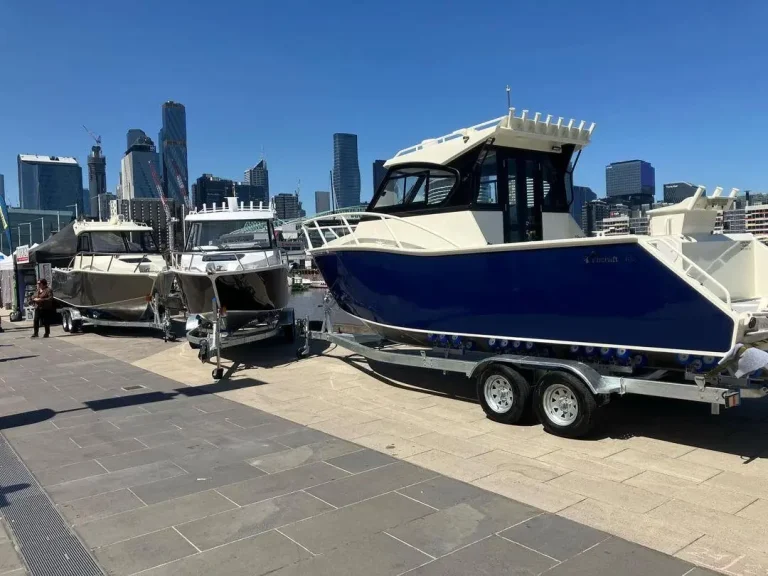 Navy plate aluminium hardtop boat on a trailer by the harbour