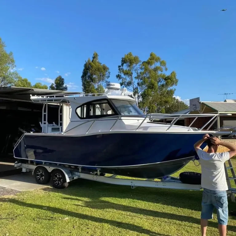 Navy plate aluminium hardtop boat parked on a lawn
