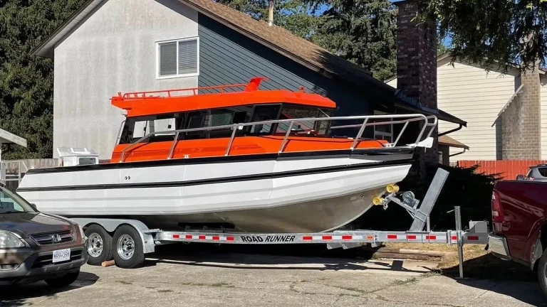Passenger boat with orange canopy on a triple axle trailer