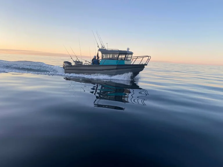 Plate aluminium boat mirrored on still water at dawn