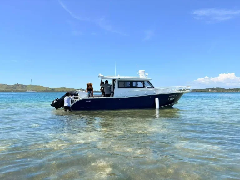 Plate aluminium cabin boat moored over sand