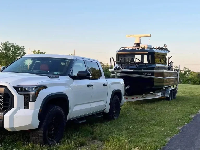 Plate aluminium hardtop boat towed behind a pickup