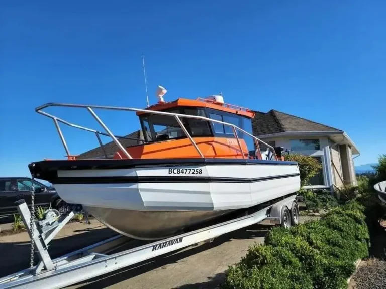 Plate aluminium hardtop boat with orange cabin on a trailer