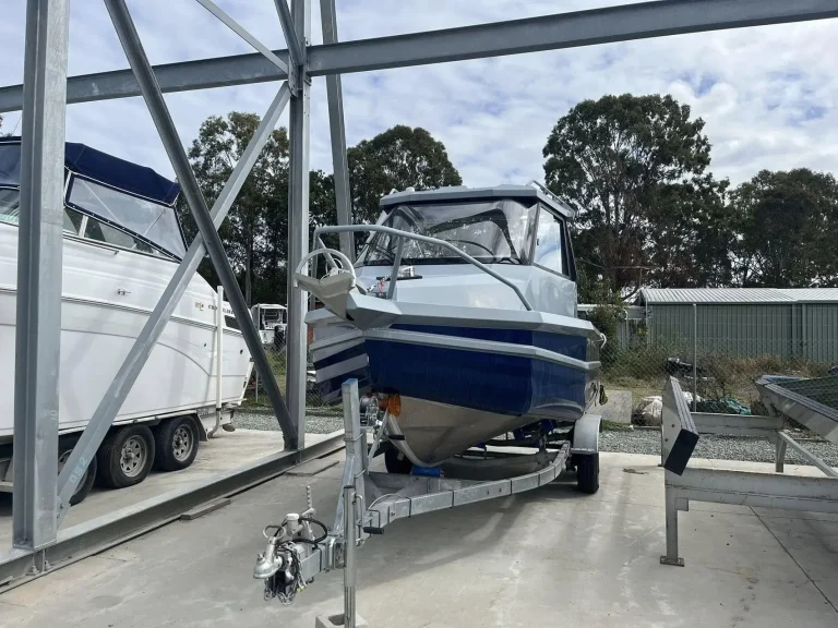 Plate aluminium hardtop boats parked under a carport