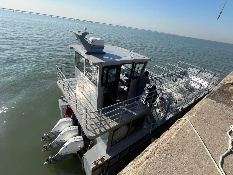 Plate aluminium work boat alongside a breakwater