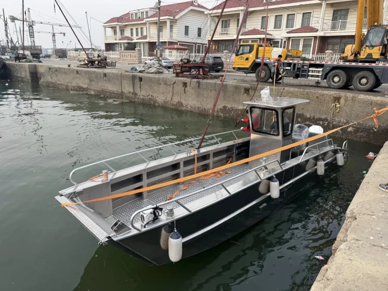 Plate aluminium work boat alongside a harbour wall