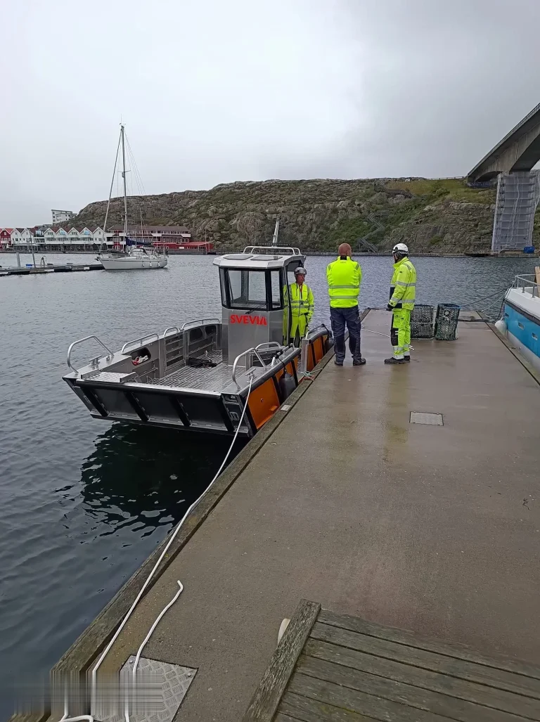 Plate aluminium work boat at a jetty with crew