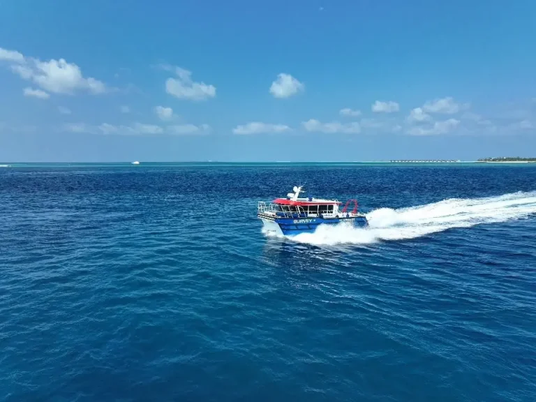 Plate aluminium work boat running across a blue lagoon