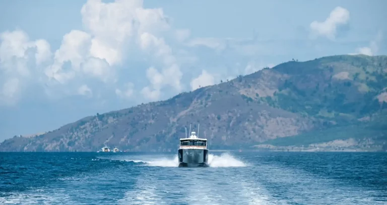 Plate aluminium work boat running past an island