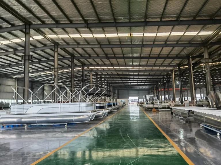 Pontoon boats lined up on the factory floor